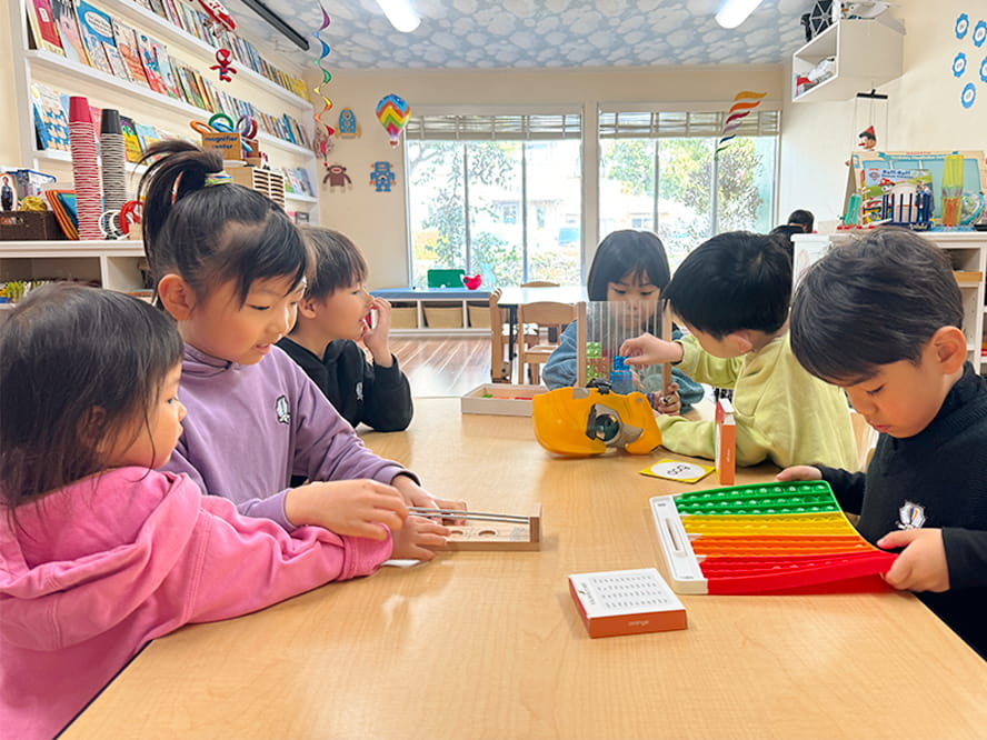 英語で会話をしながら気に入ったおもちゃで遊ぶ生徒たち