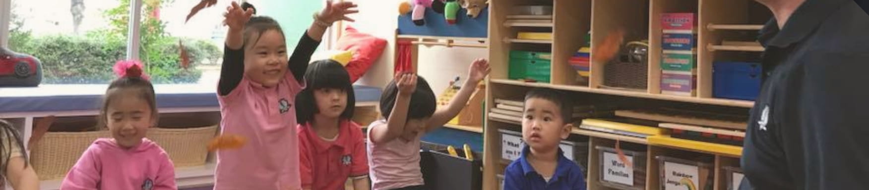 笑顔で手を挙げながら講師の話を聞く生徒たち