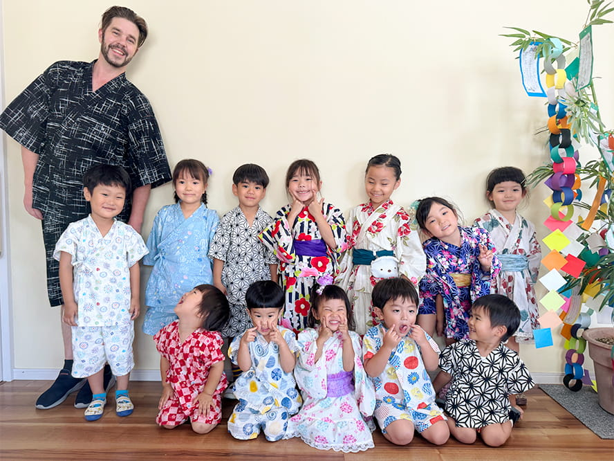 浴衣を着て七夕のイベントを楽しむ講師と笑顔でポーズを決める生徒たち