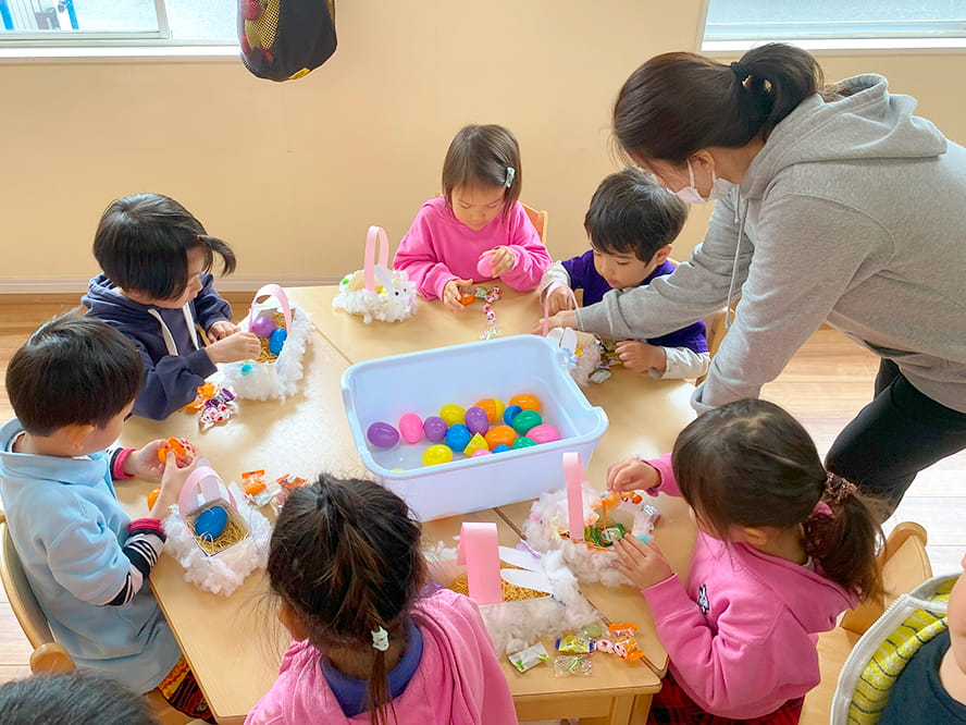 カラフルなボールを使い授業をしているフランクリンスクール倉敷校の女性講師と生徒さん達