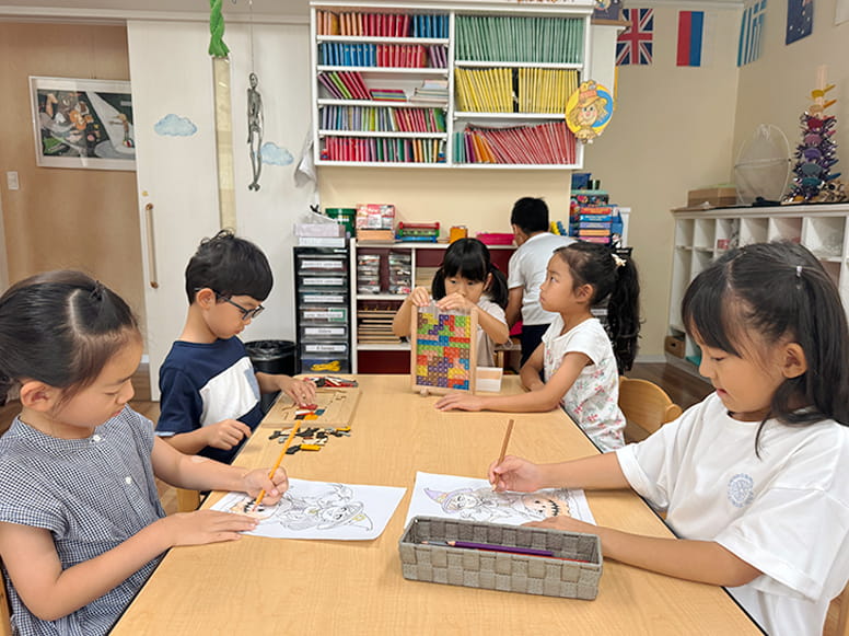 それぞれ絵をかいたりパズルをしたり積み木をしたりしながら学んでいる生徒