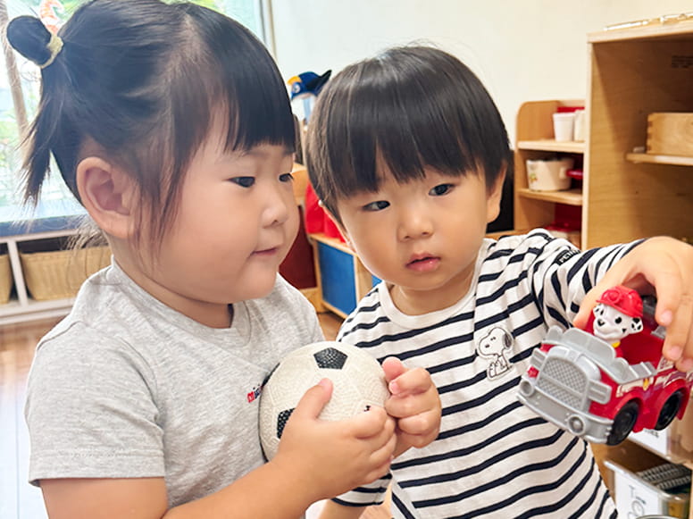 使ったボールや車のおもちゃを片付ける生徒たち