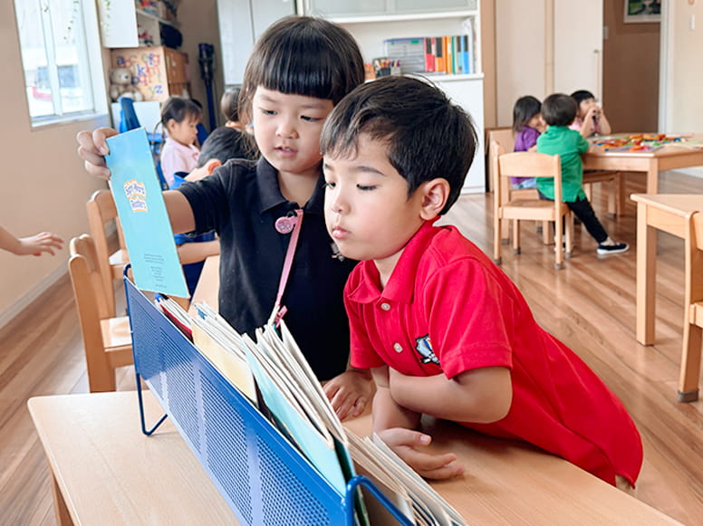 どんな絵本を読もうかと本棚とにらめっこする生徒たち